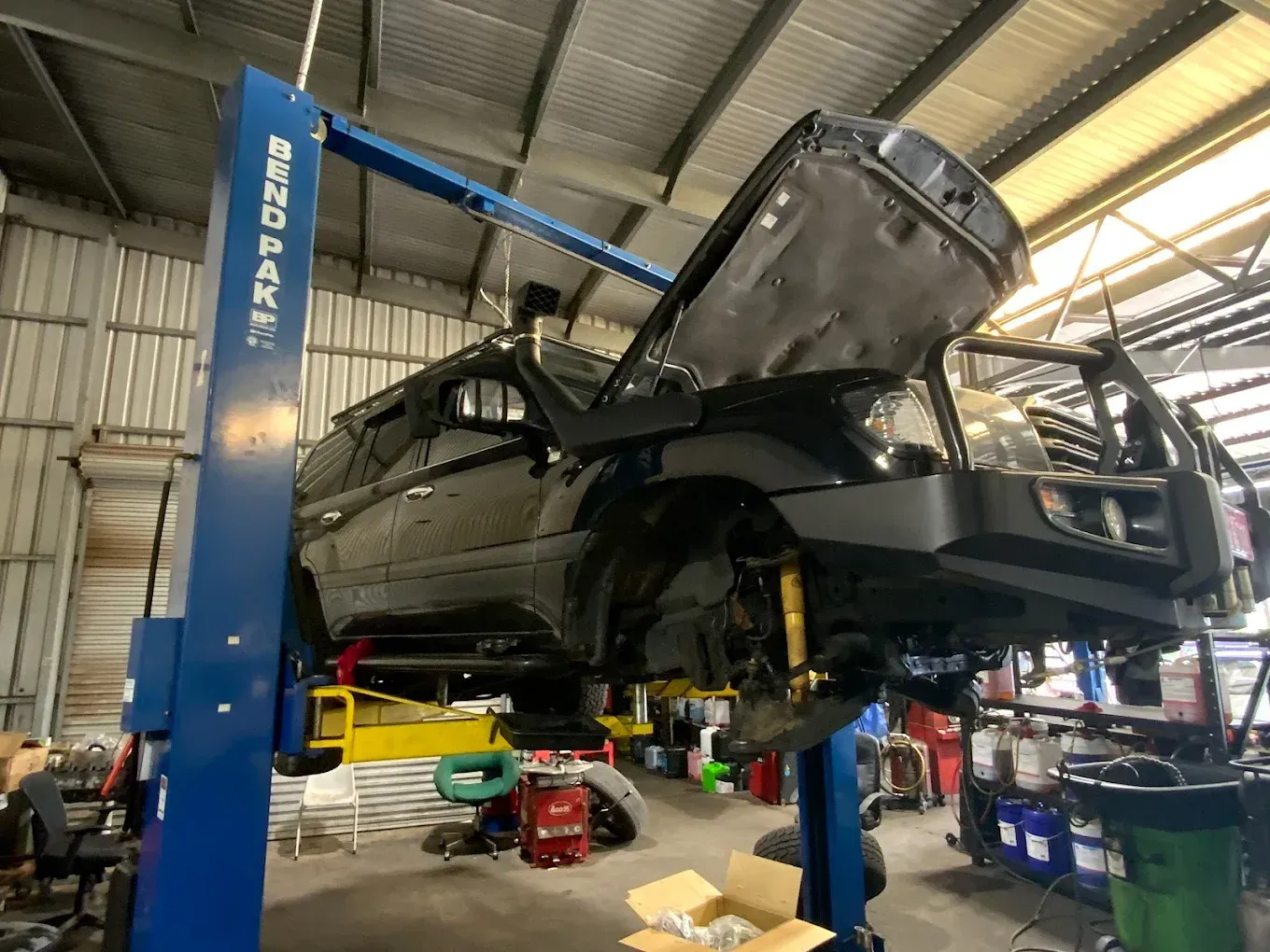 A Car is Sitting on a Lift in a Garage — Toowoomba Lube & Mechanical in Glenvale, QLD