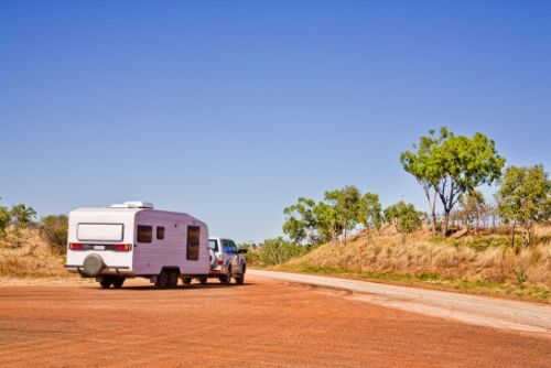 A White RV is Parked on the Grass Next to a Lake — Toowoomba Lube & Mechanical in Glenvale, QLD
