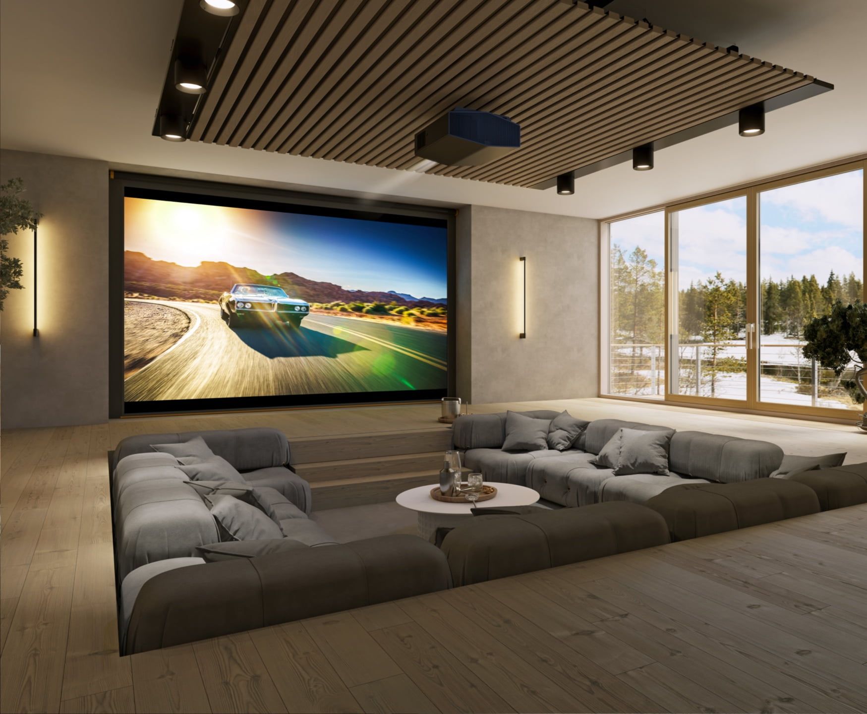 Modern living room with a large wall screen, sectional sofa, and floor-to-ceiling windows overlooking trees