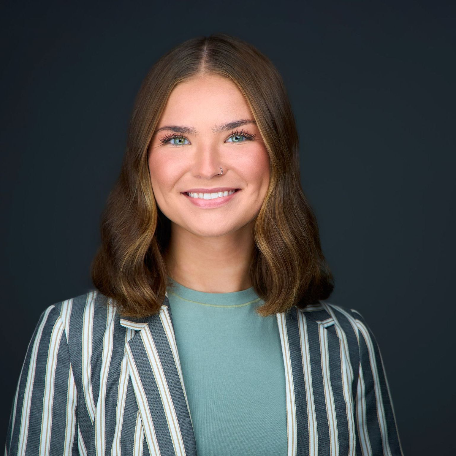 Kylie Pilarchik A woman is wearing a striped jacket and smiling for the camera.