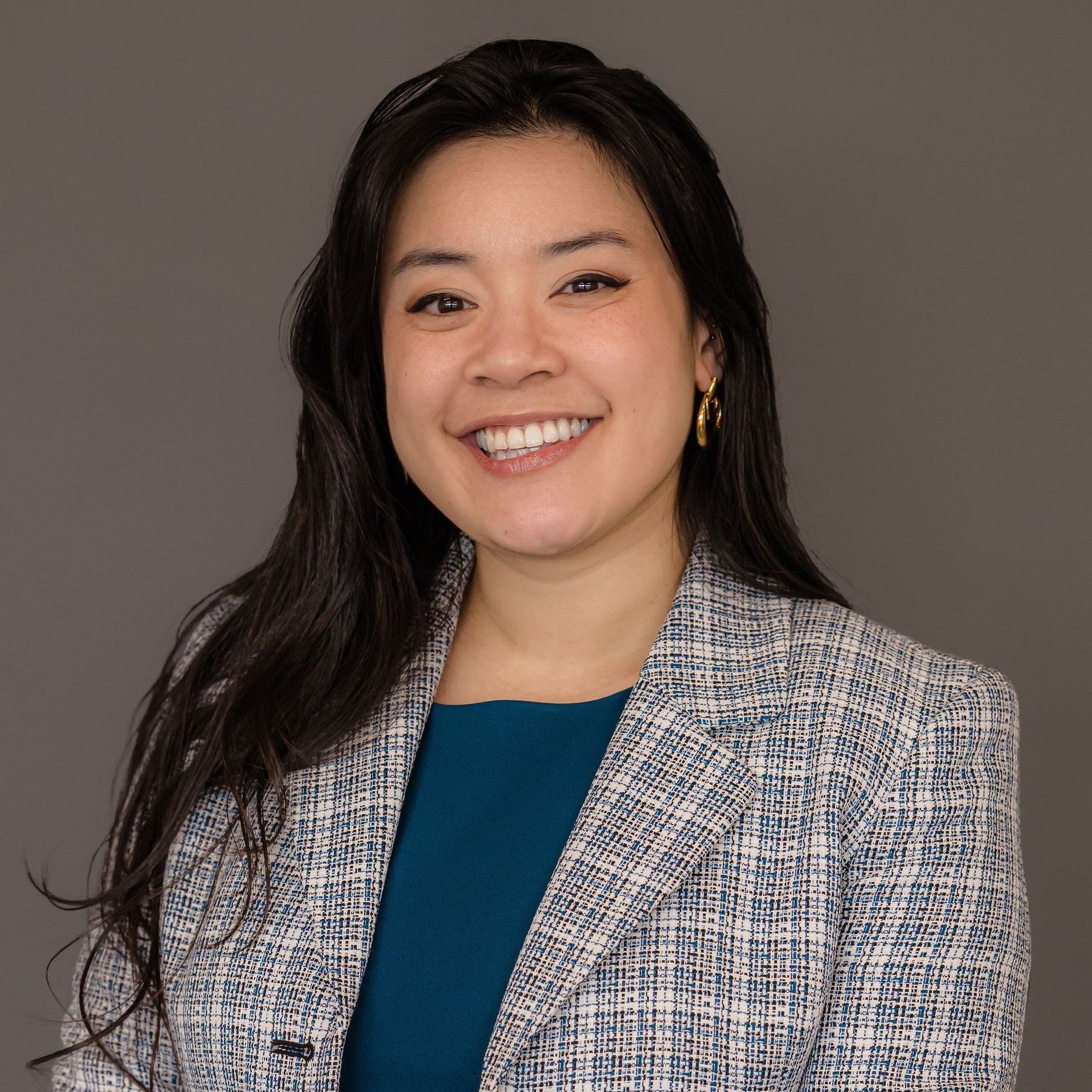 David R. Didio, Esq. A woman wearing a blue shirt and a jacket is smiling for the camera.