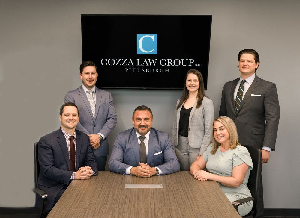 A group of people are posing for a picture while sitting around a table.