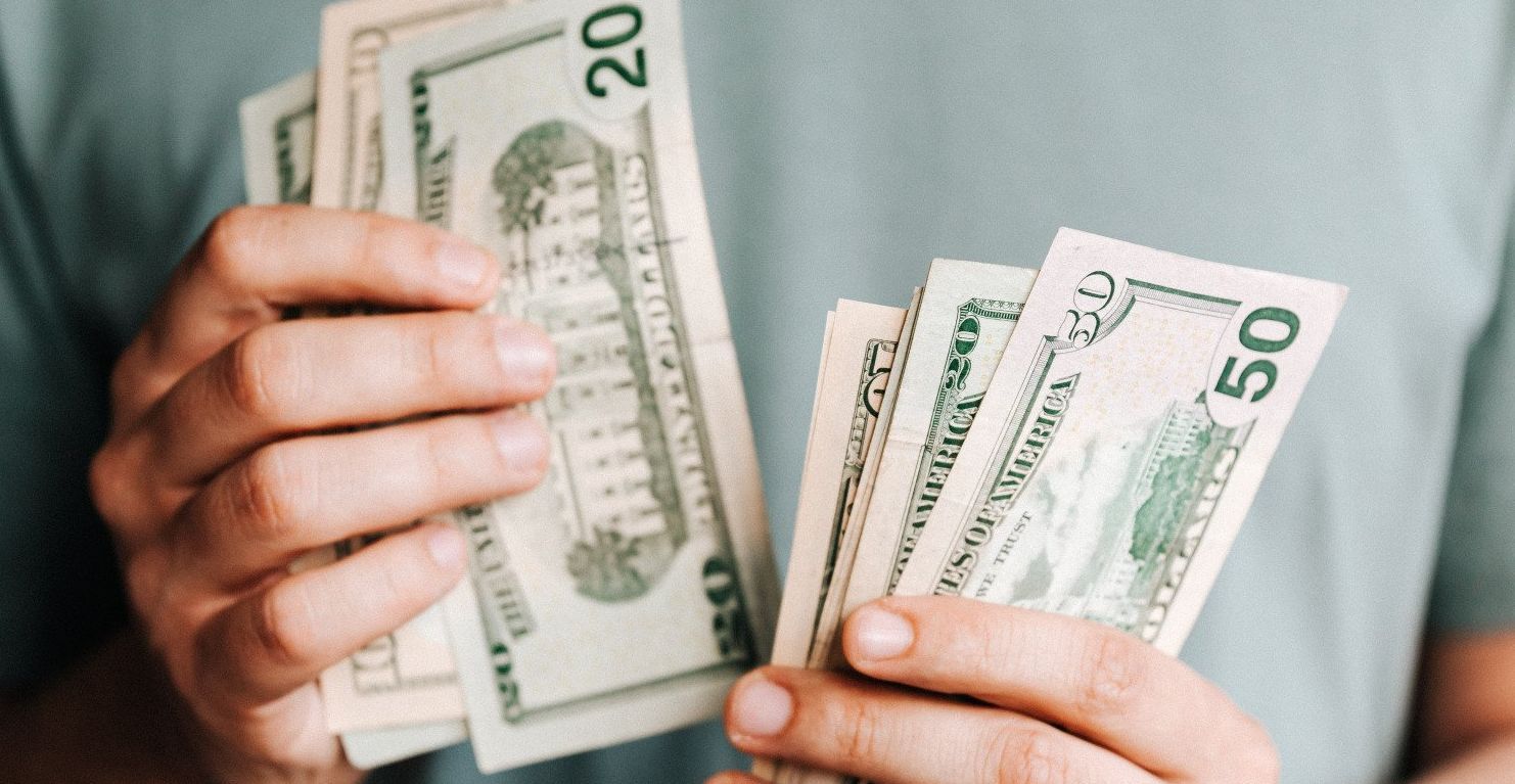 A man is holding a bunch of money in his hands.