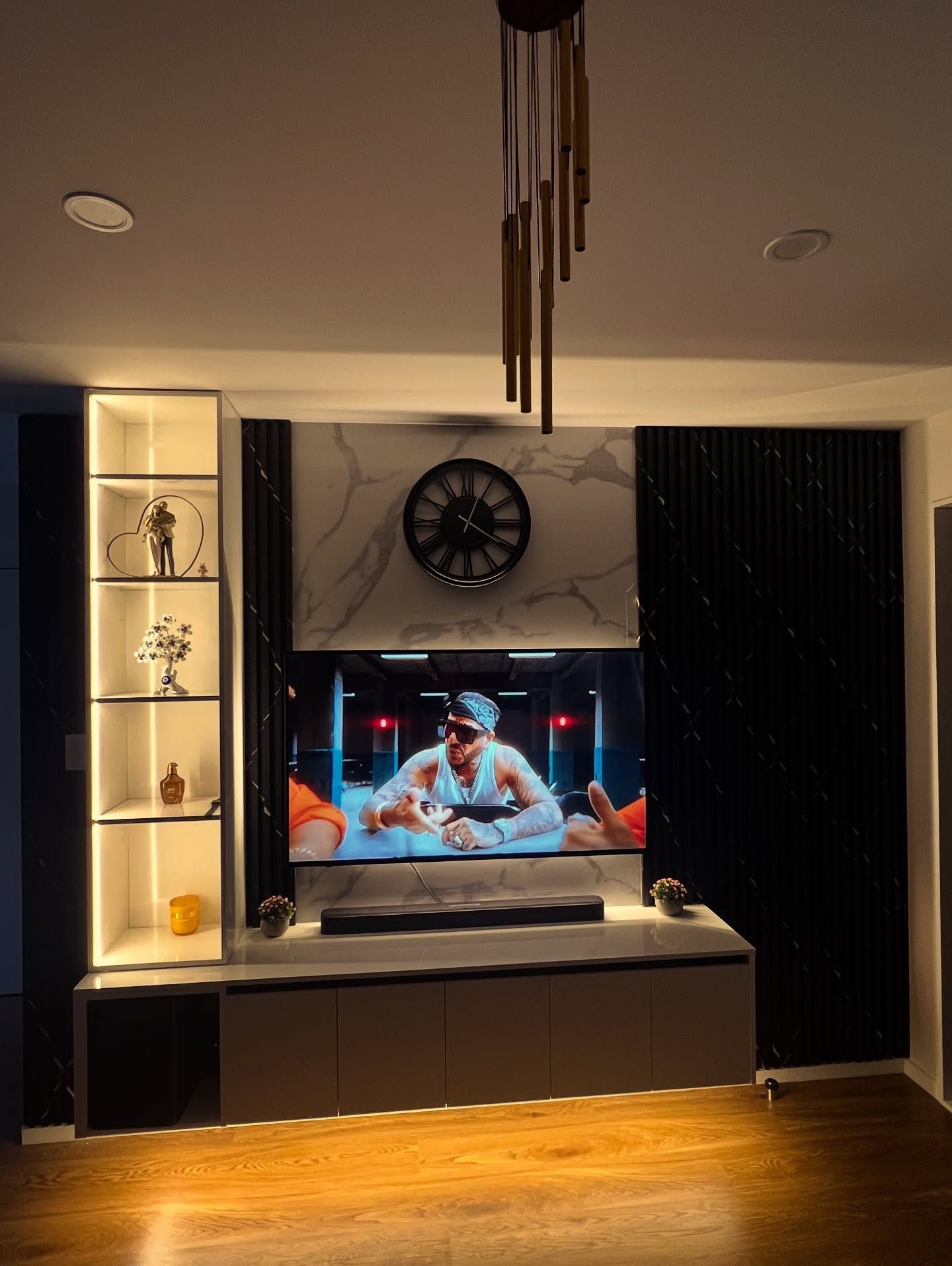 Modern media wall with a large TV, built-in shelves, and decorative lighting.