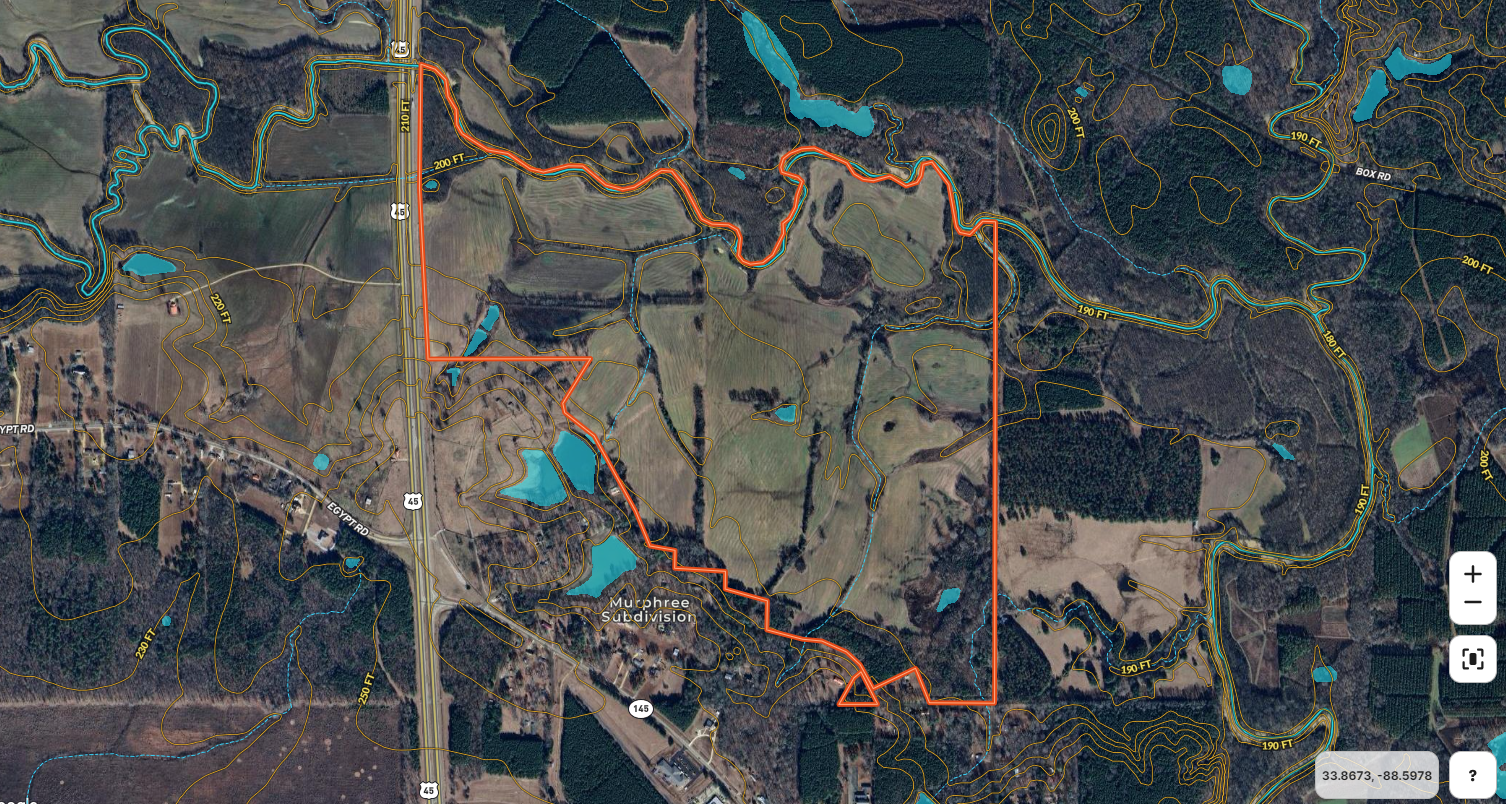 An aerial view of a farm with a red line going through it.