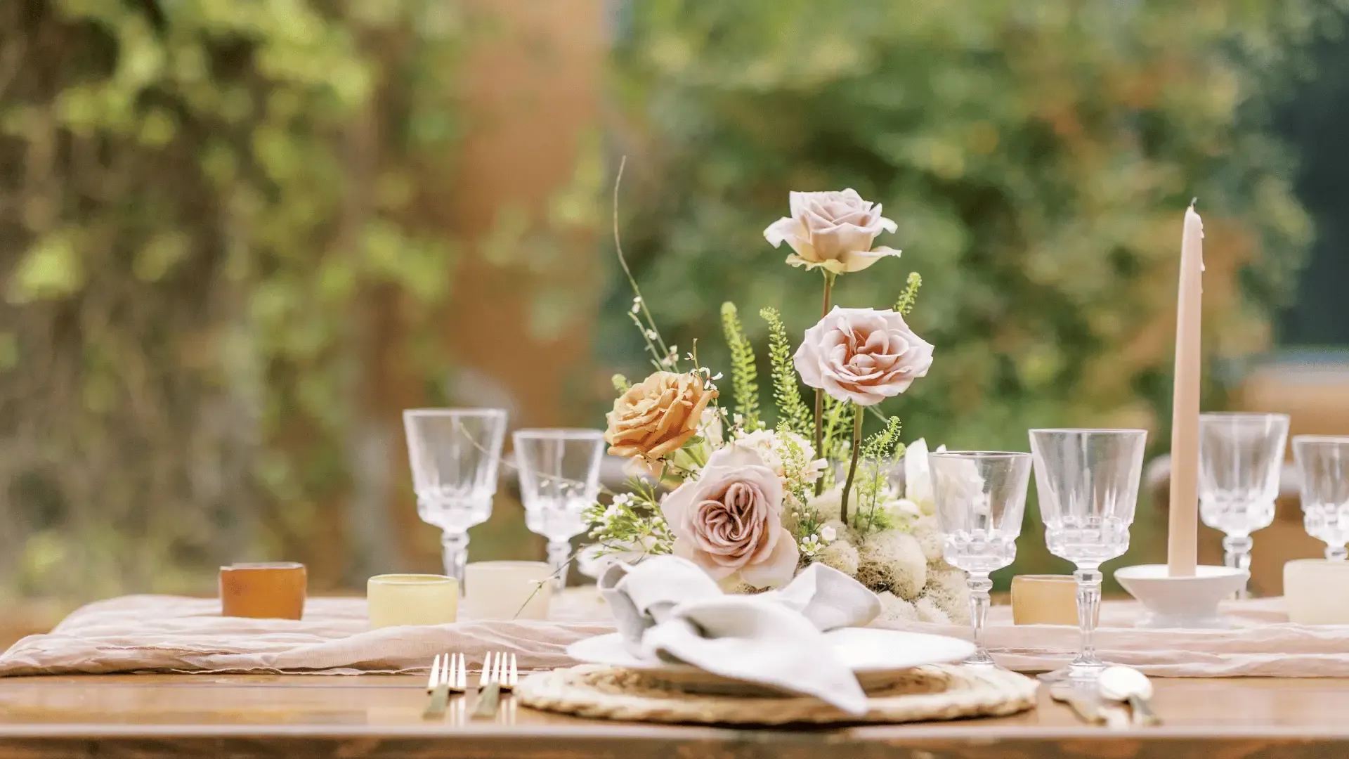 A table set for a wedding reception with flowers and wine glasses.