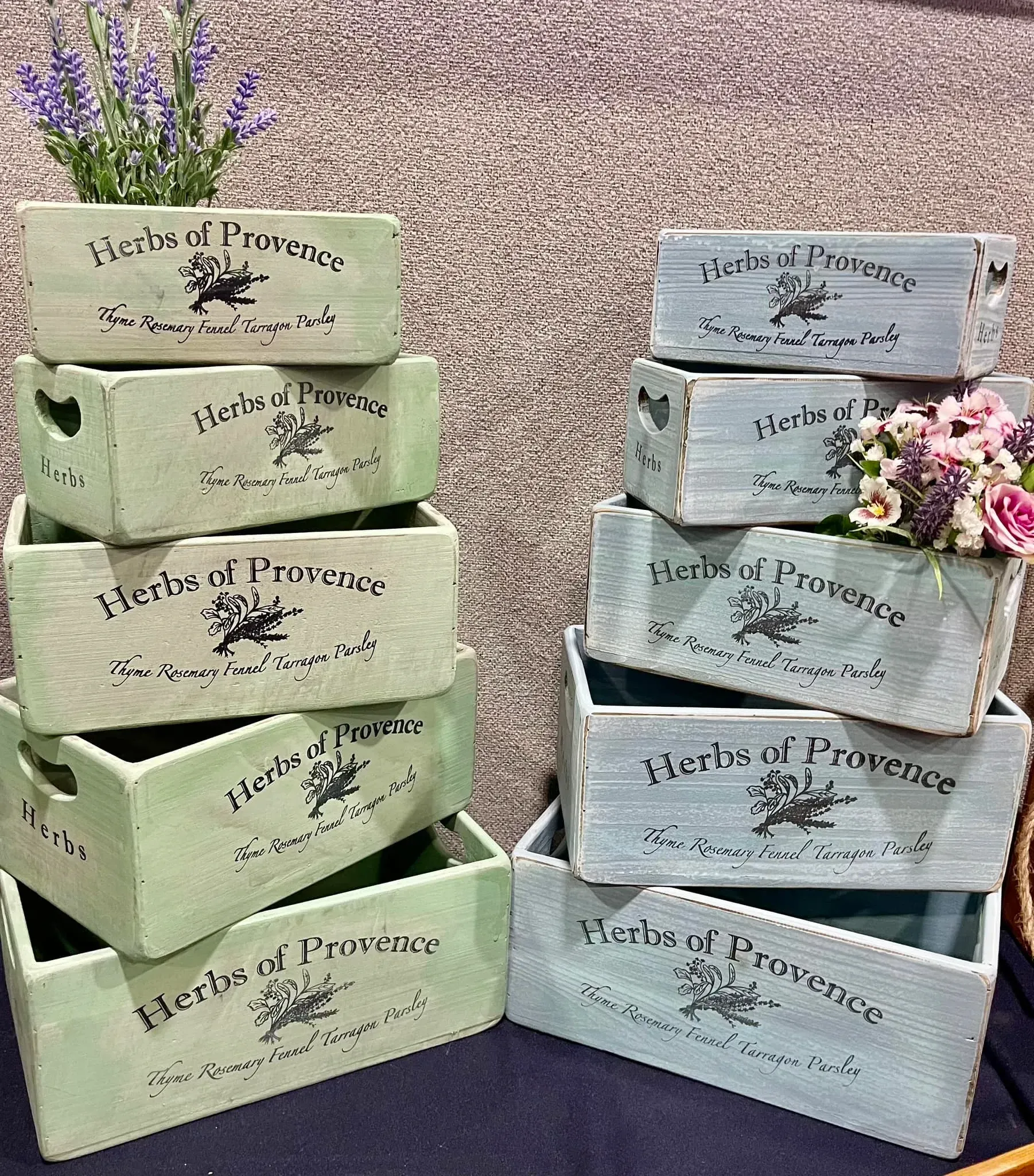 A bunch of wooden boxes stacked on top of each other with flowers in them.