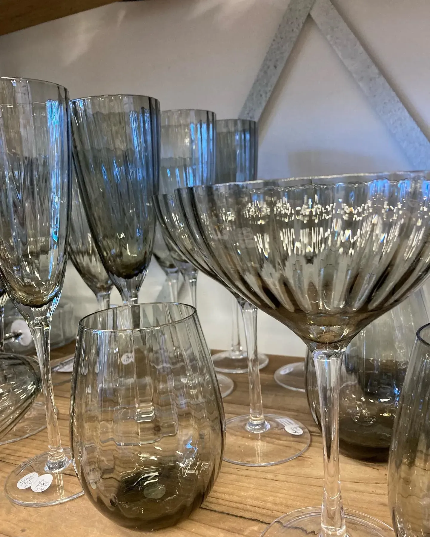 A bunch of wine glasses are sitting on a wooden table.