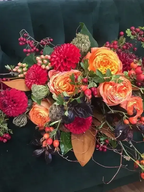 a bouquet of flowers is sitting on a green couch