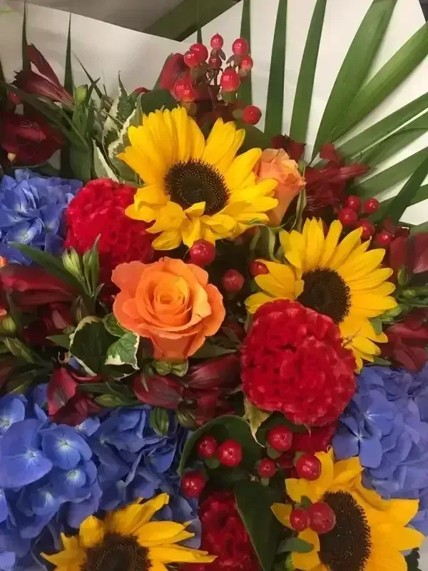 Brighten My Day - Buy Now! A close up of a bouquet of flowers including sunflowers and roses