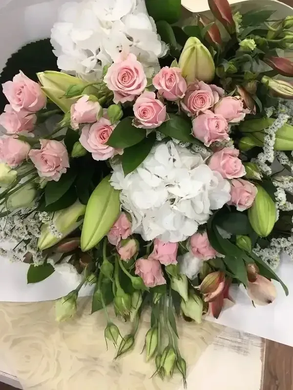 A bouquet of pink and white flowers is sitting on a table.
