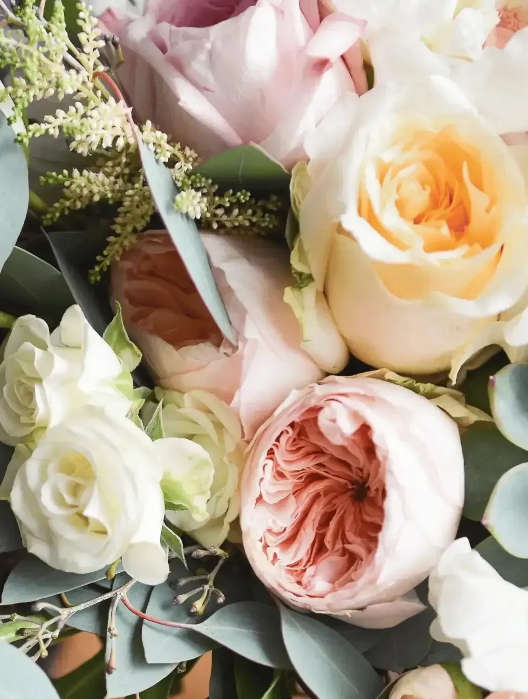 A close up of a bunch of flowers including roses
