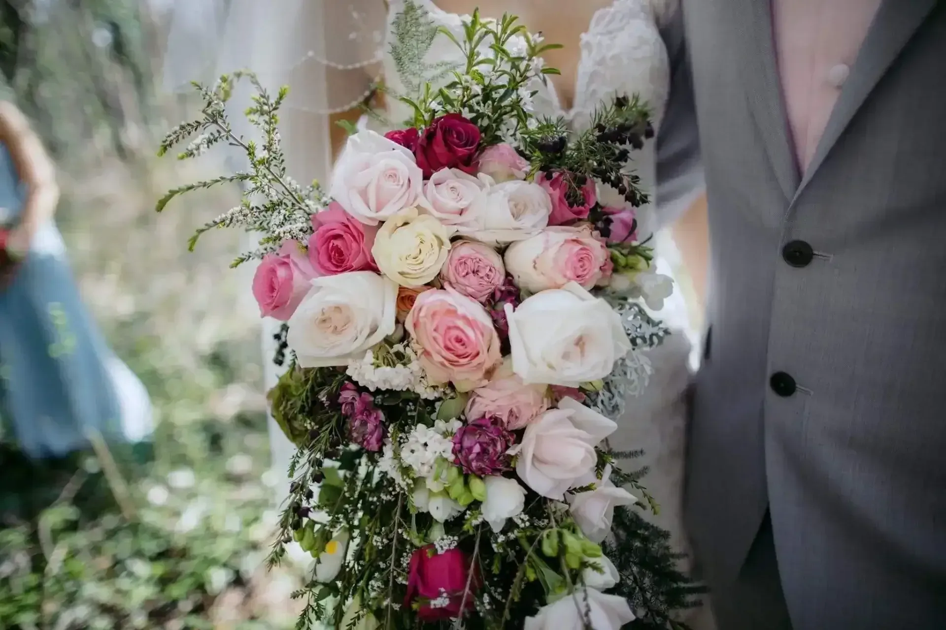 A bride and groom are holding a bouquet of flowers.