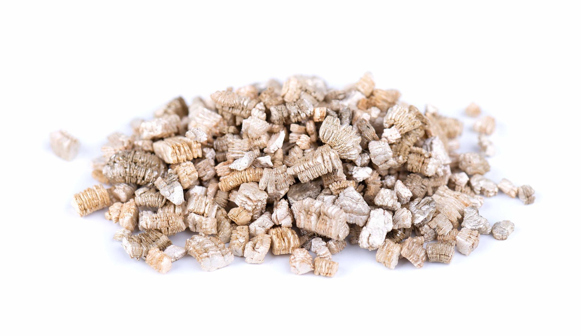 Tas de gros morceaux de vermiculite brun clair sur fond blanc.