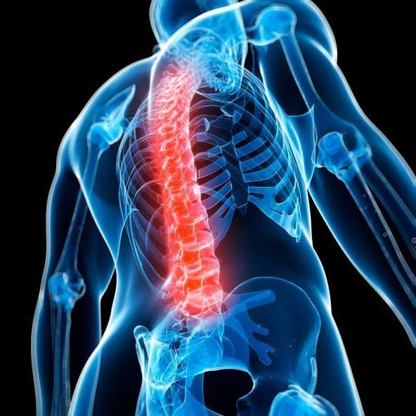 Person sitting and holding lower back, with highlighted glowing pain area on the spine near the pelvis