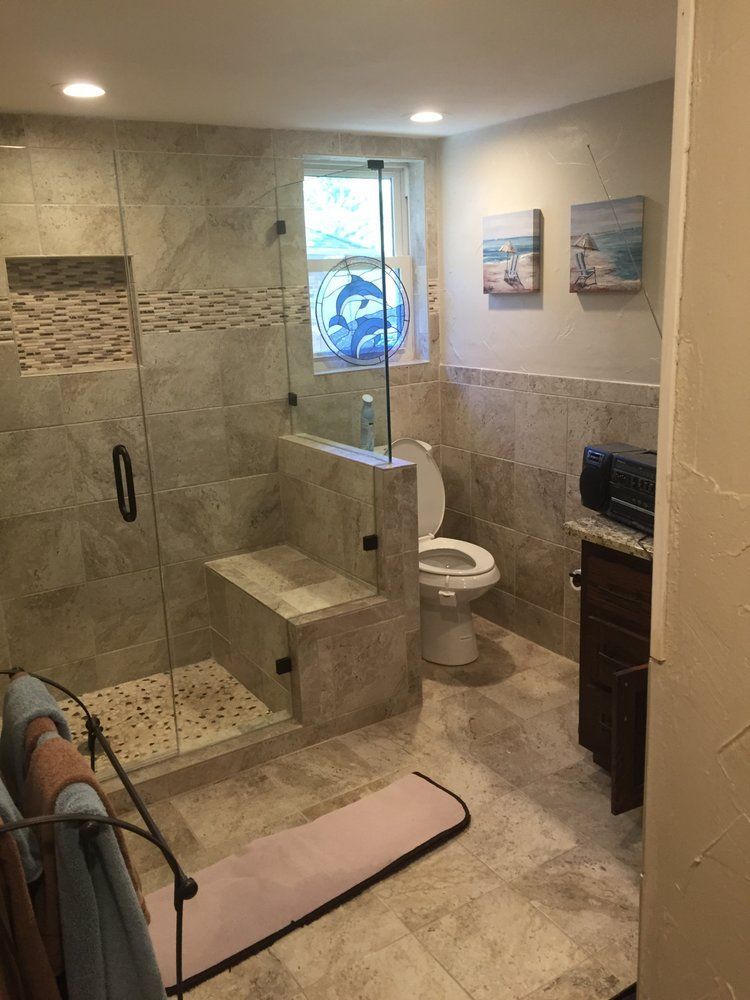 A bathroom with a toilet and a walk in shower.