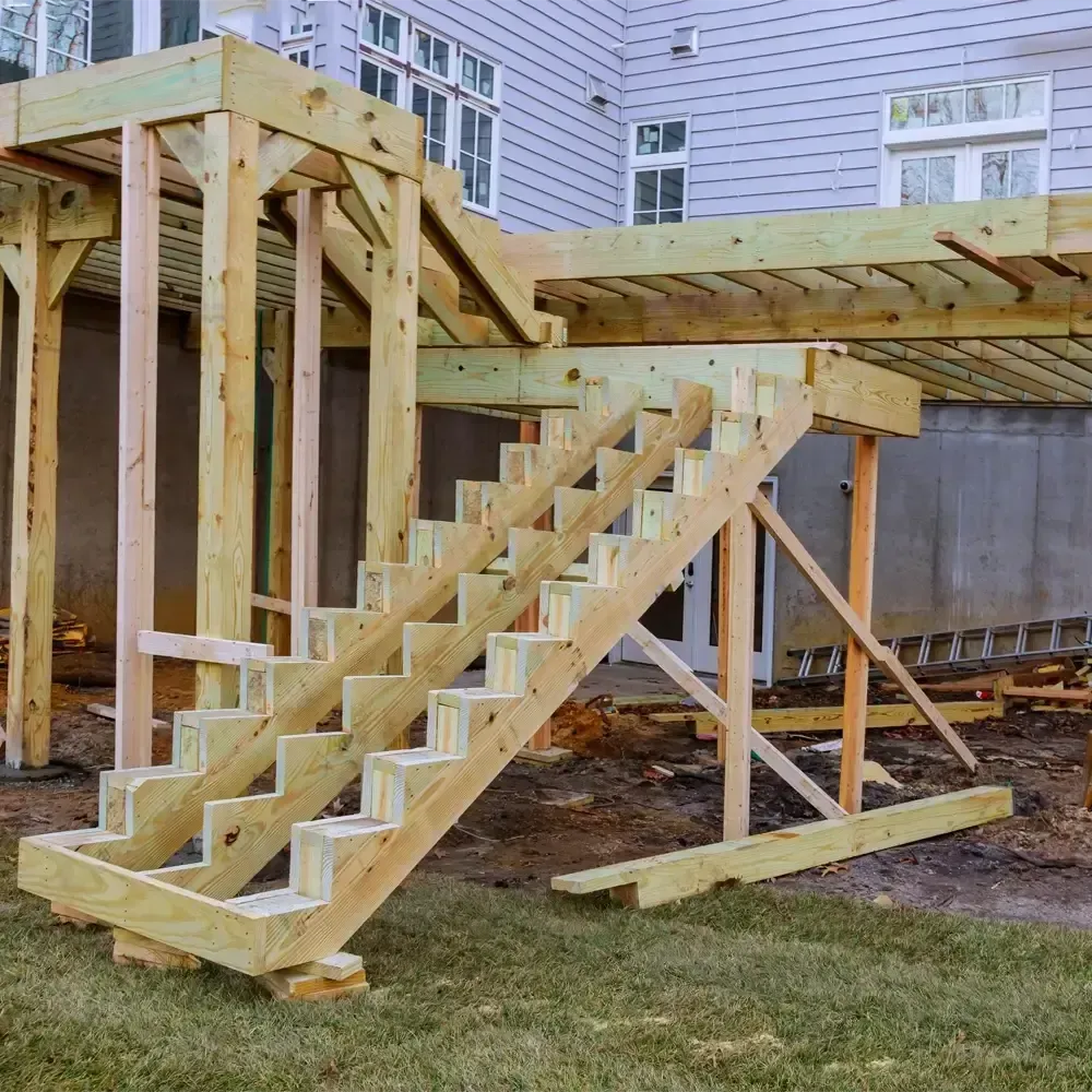 A wooden deck is being built with wooden stairs