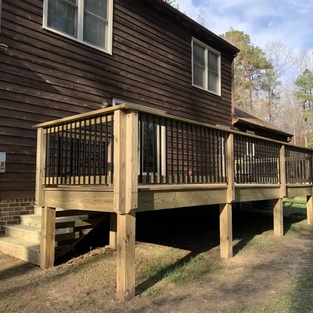A brown house with a wooden deck in front of it