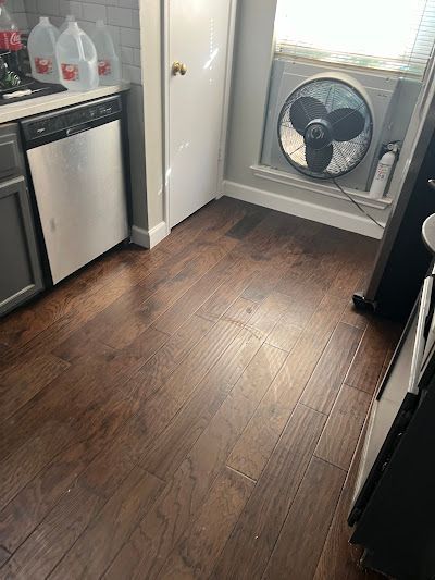A man is installing a wooden floor in a room.
