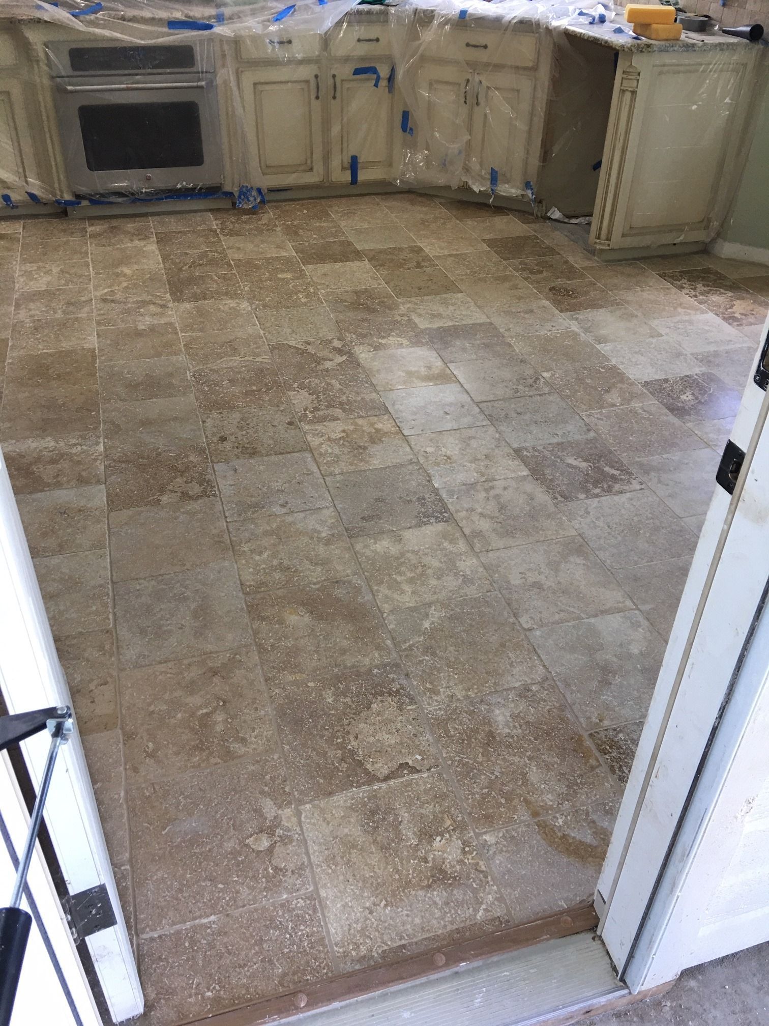 A kitchen with a tile floor and white cabinets.