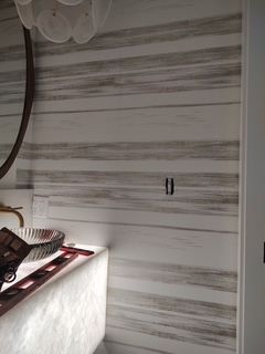 White wood-grain wall with a small cabinet and a plate of fruit in a kitchen or dining area