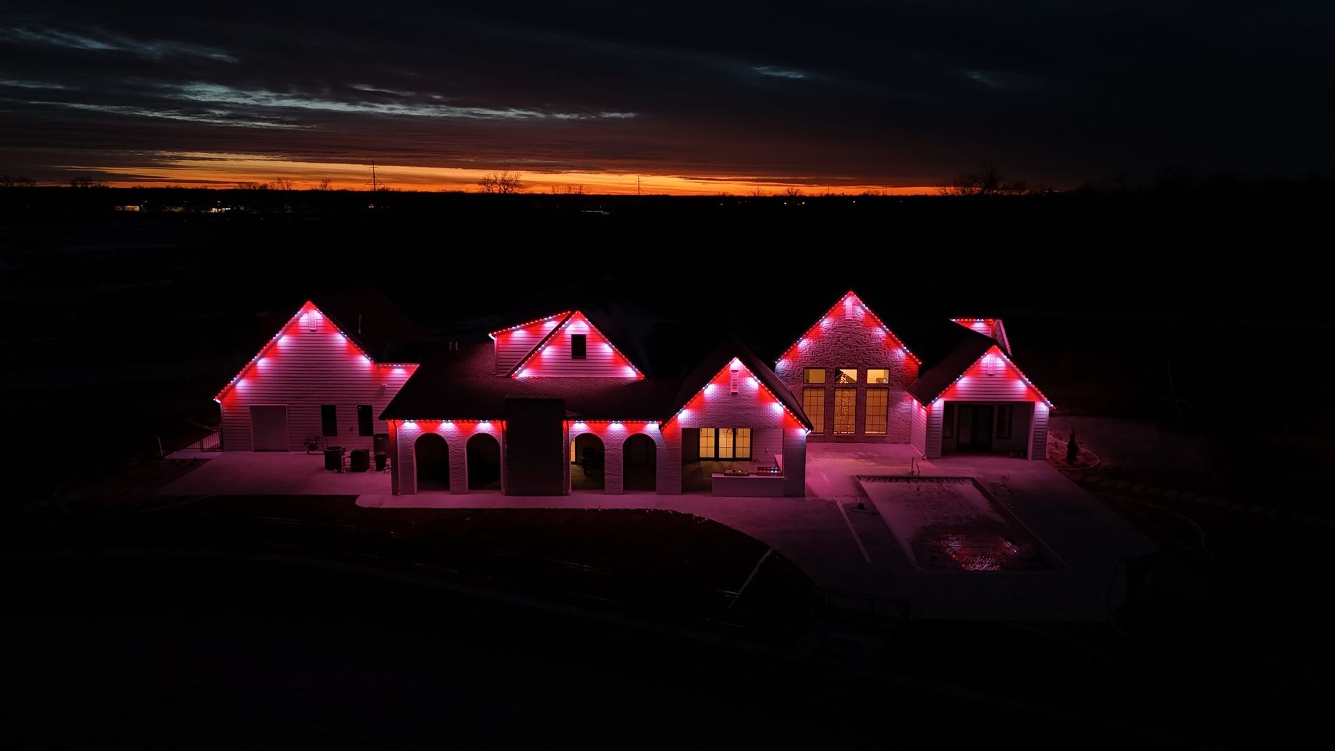 House decorated with bright pink lights at night under a dark sky