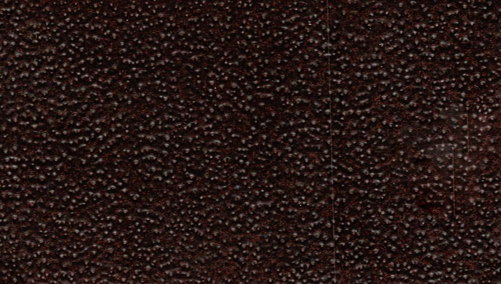 Close-up of a dark brown, textured surface with a subtle pebbled pattern