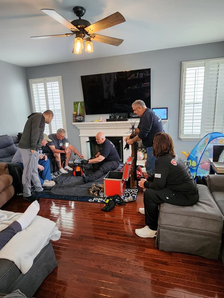 A group of people are working on a fireplace in a living room.