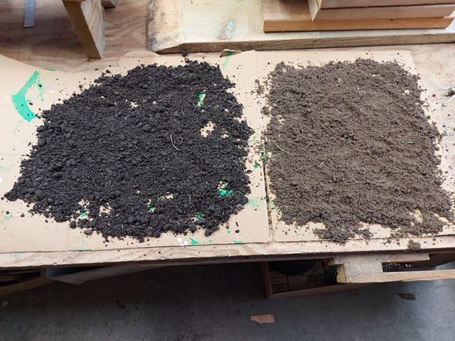 Two piles of soil, one dark and one light brown, sit side-by-side on a wooden surface.