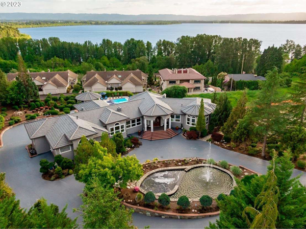 A large house with a lot of windows and a garage on a rainy day.