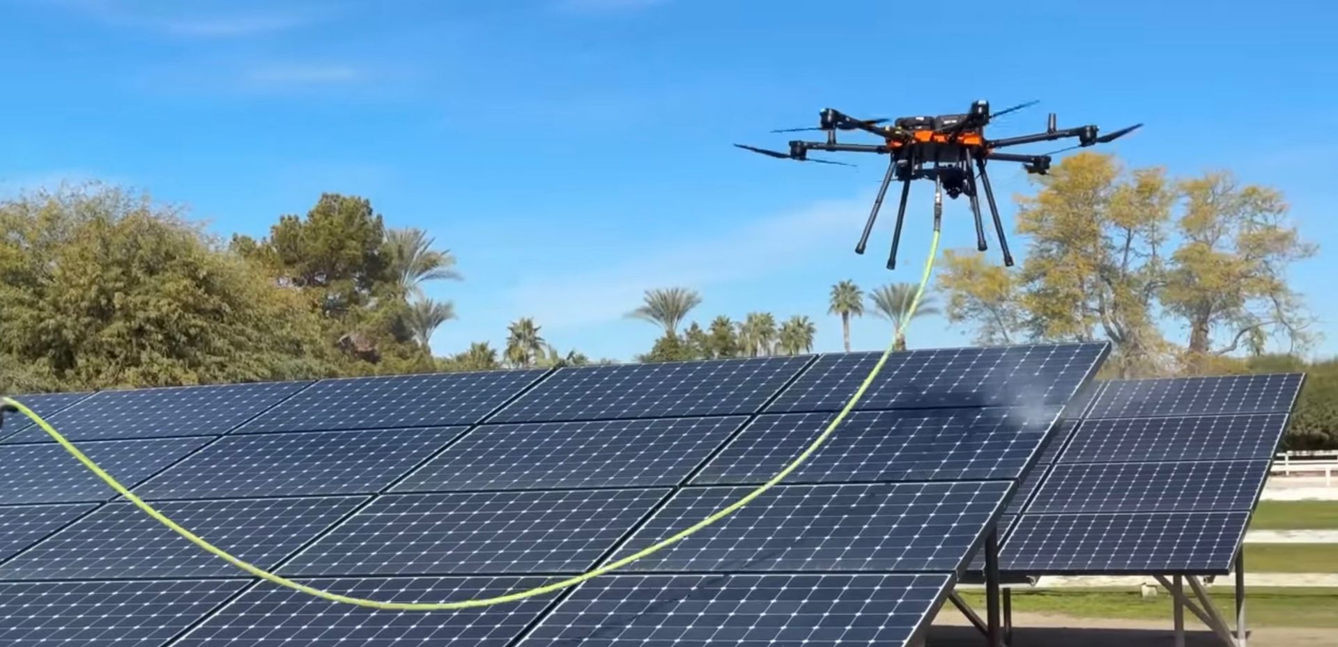 A group of solar panels are sitting on top of a roof next to a pool.