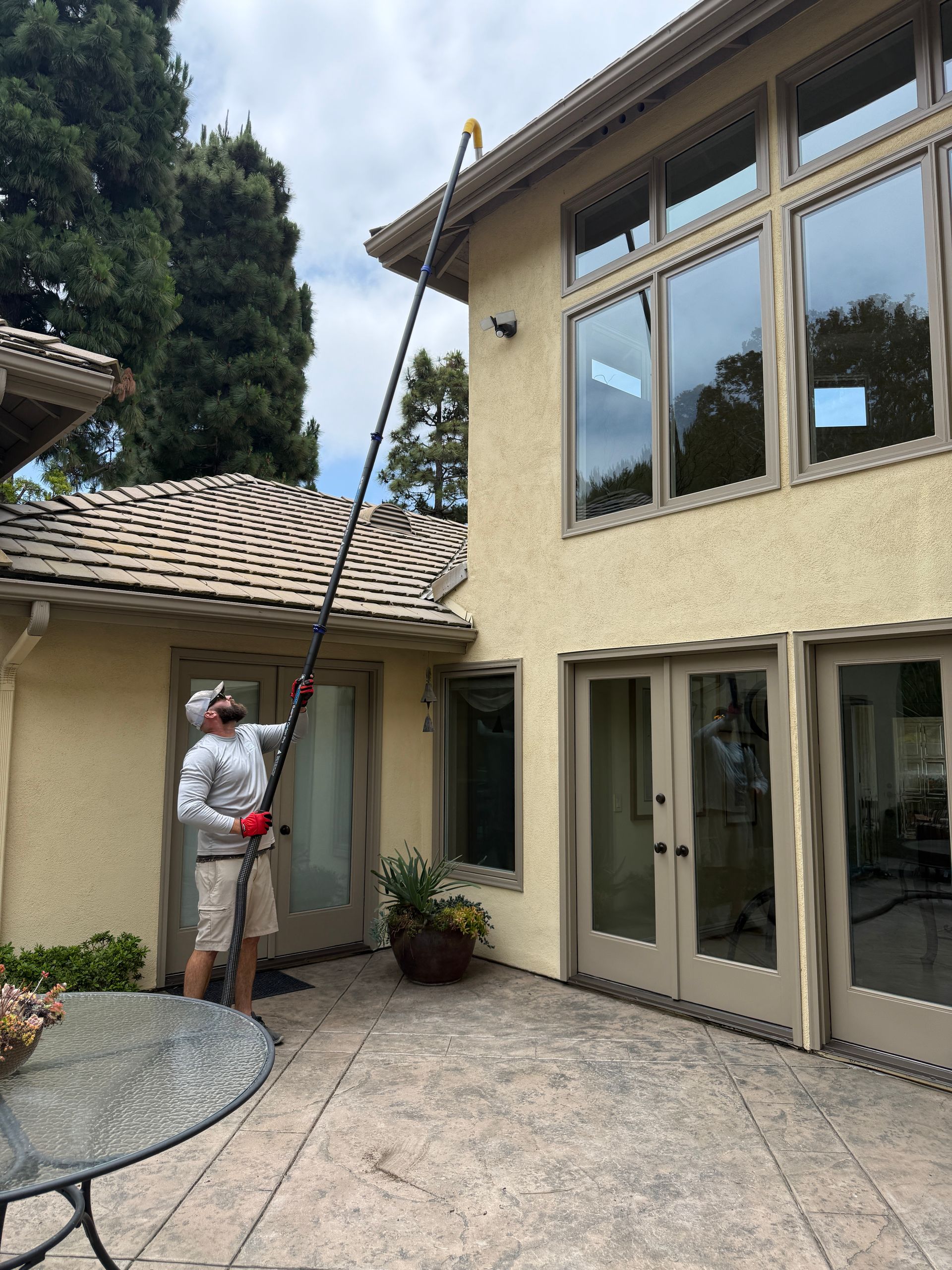 A man is cleaning the windows of a house