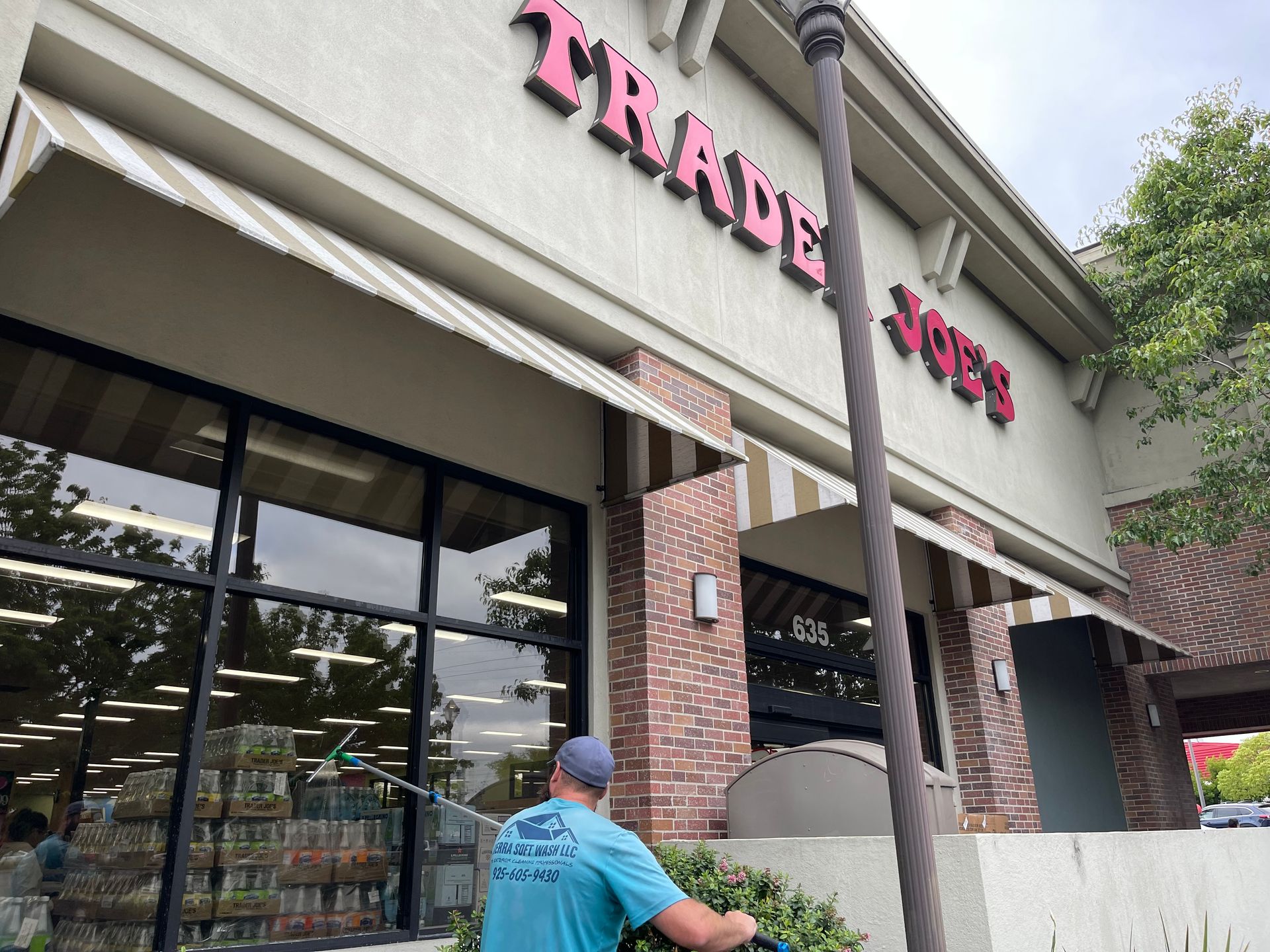 A man is standing in front of a trader joes store