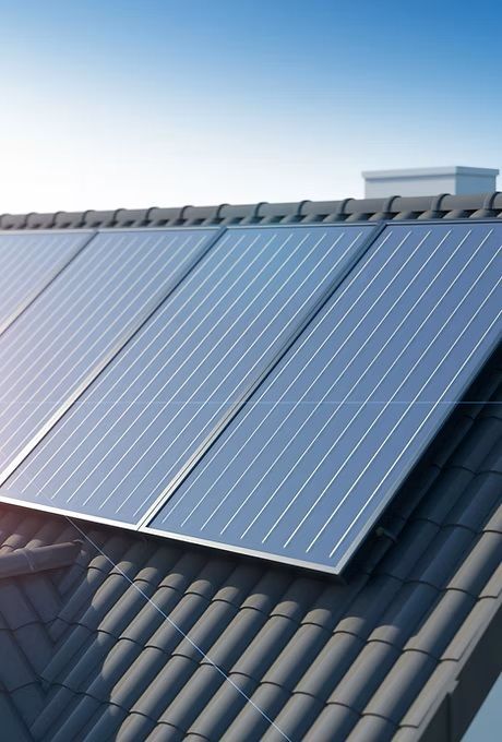 There are many solar panels on the roof of a house.