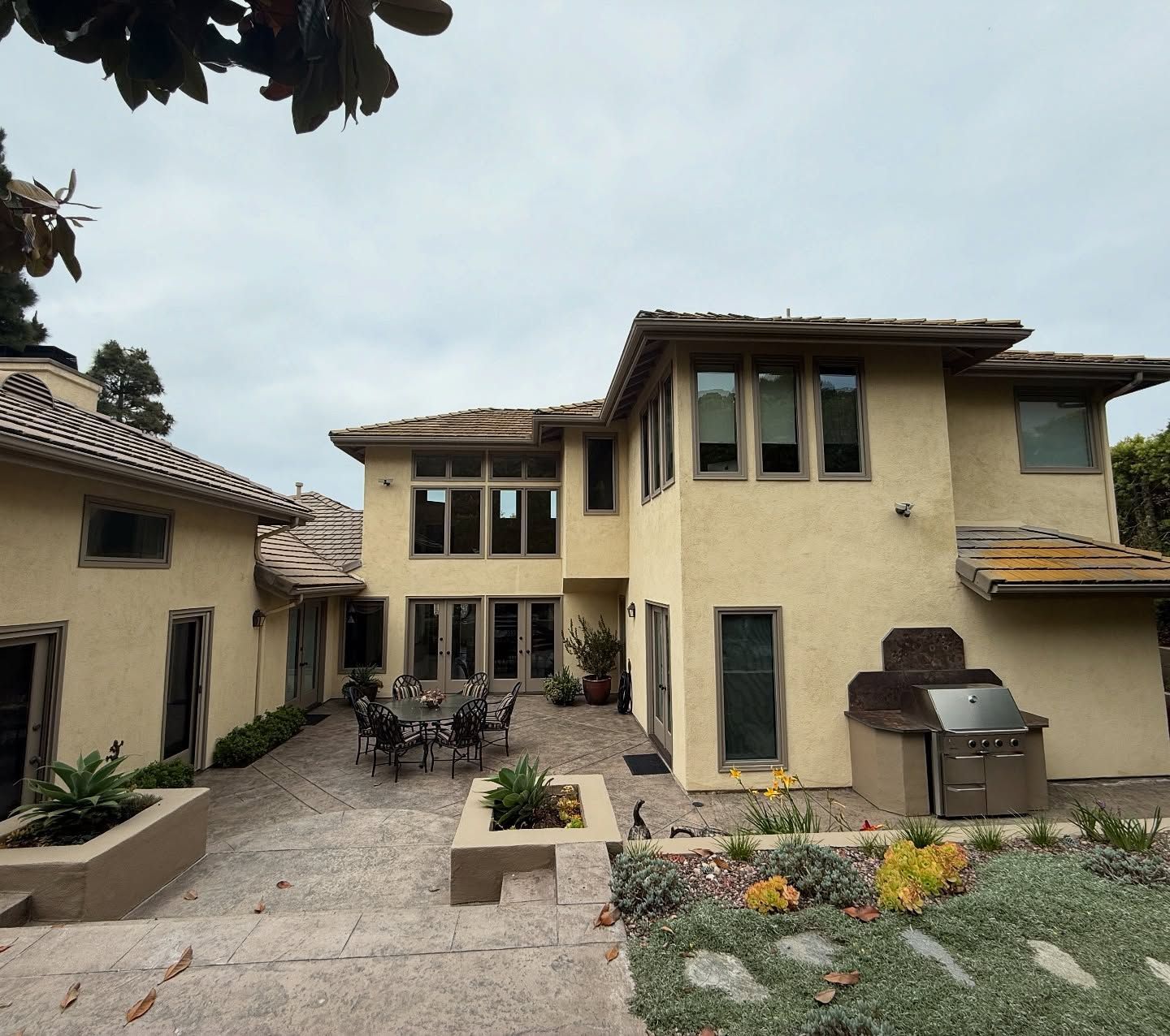 A large house with a lot of windows and a grill