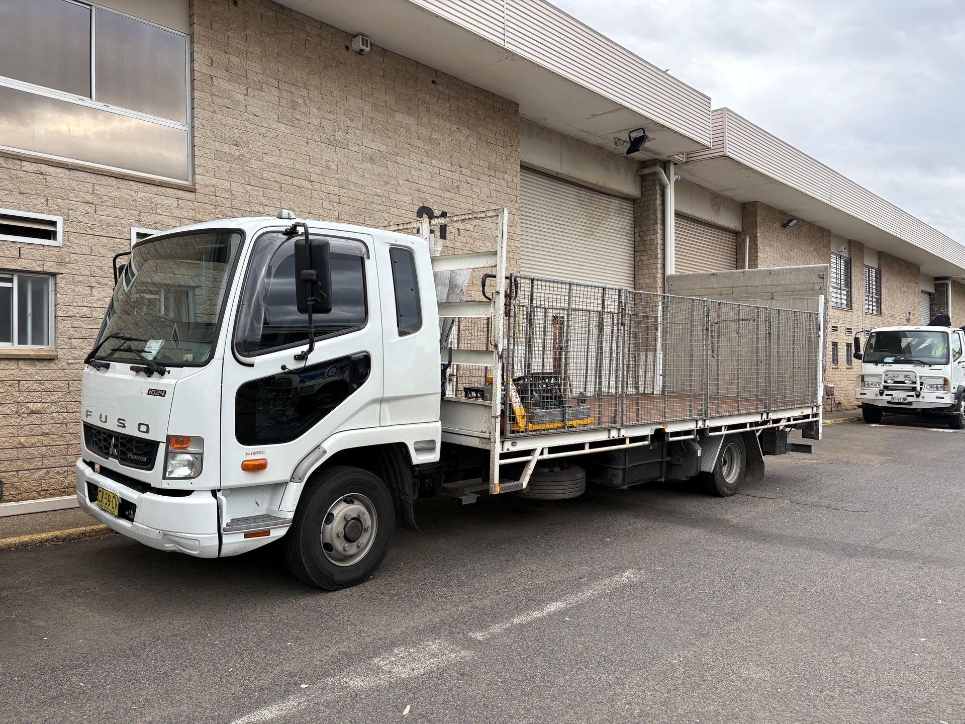 White flatbed tailgate truck.