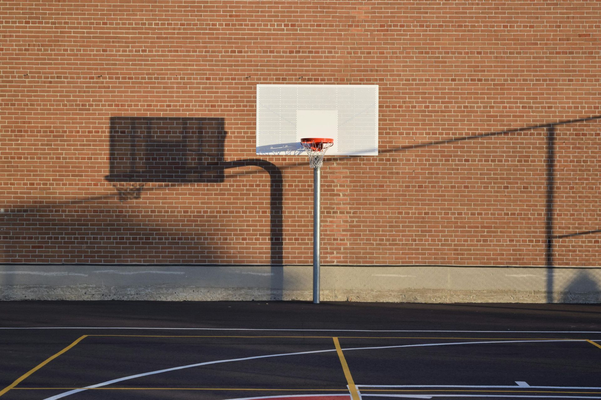A basketball court with a brick wall behind it