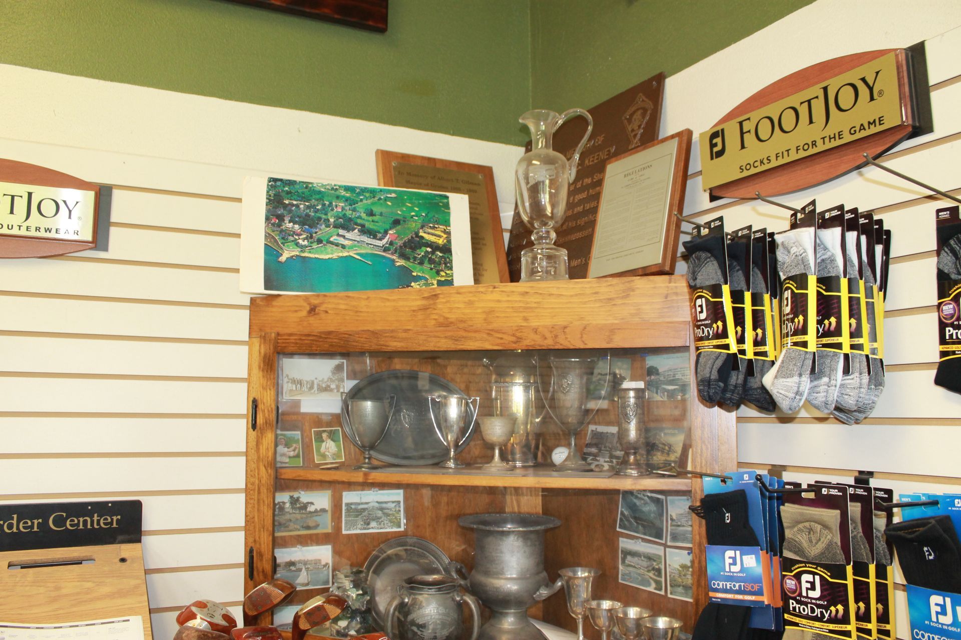 Gift shop display of silverware, mugs, and souvenirs on shelves in a small store
