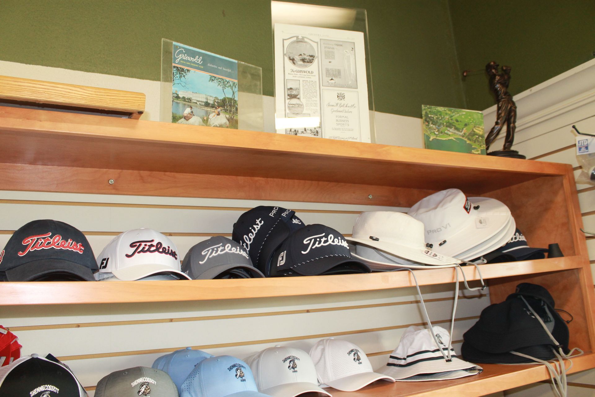 Shelves with rows of baseball caps and a few boxes displayed in a shop or storage area