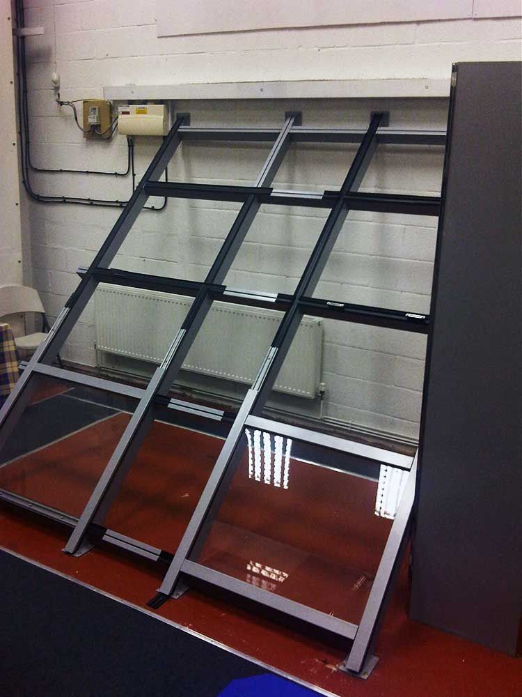 Leaning metal-framed display panels with red posters in a showroom or workshop room