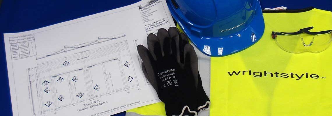 Wrist safety supplies on a desk: black gloves, blue bottle, paper sketch, and neon yellow wrist tape.