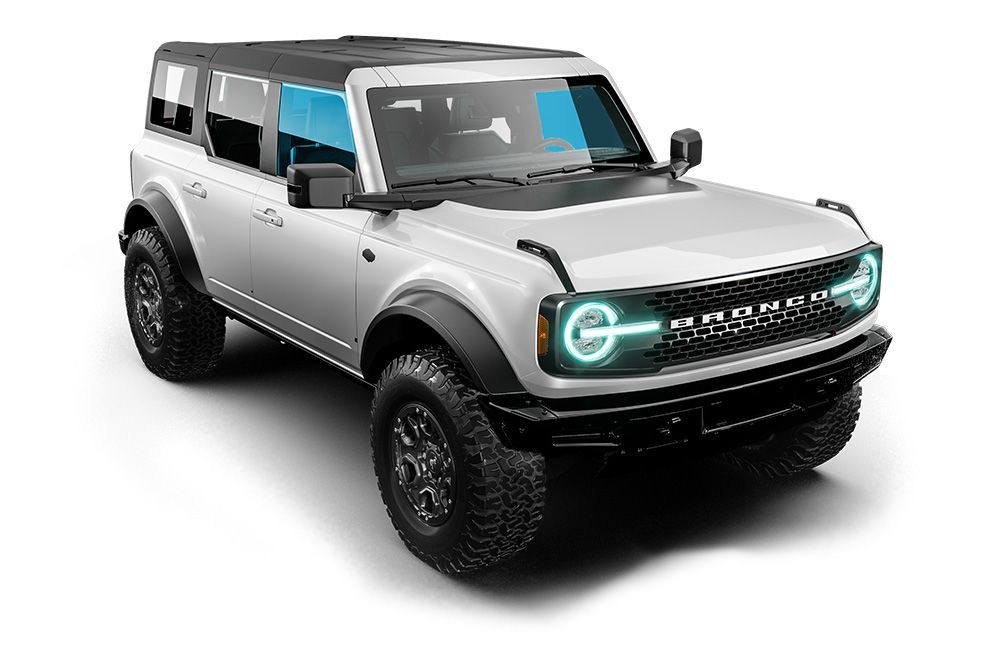 Silver off-road SUV with black trim, teal headlights, and rugged tires on a white background