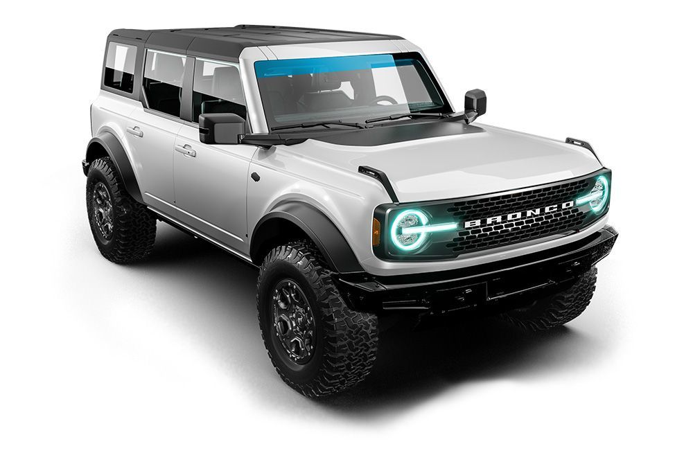 Silver off-road SUV with black trim, large tires, and glowing teal headlights on a white background
