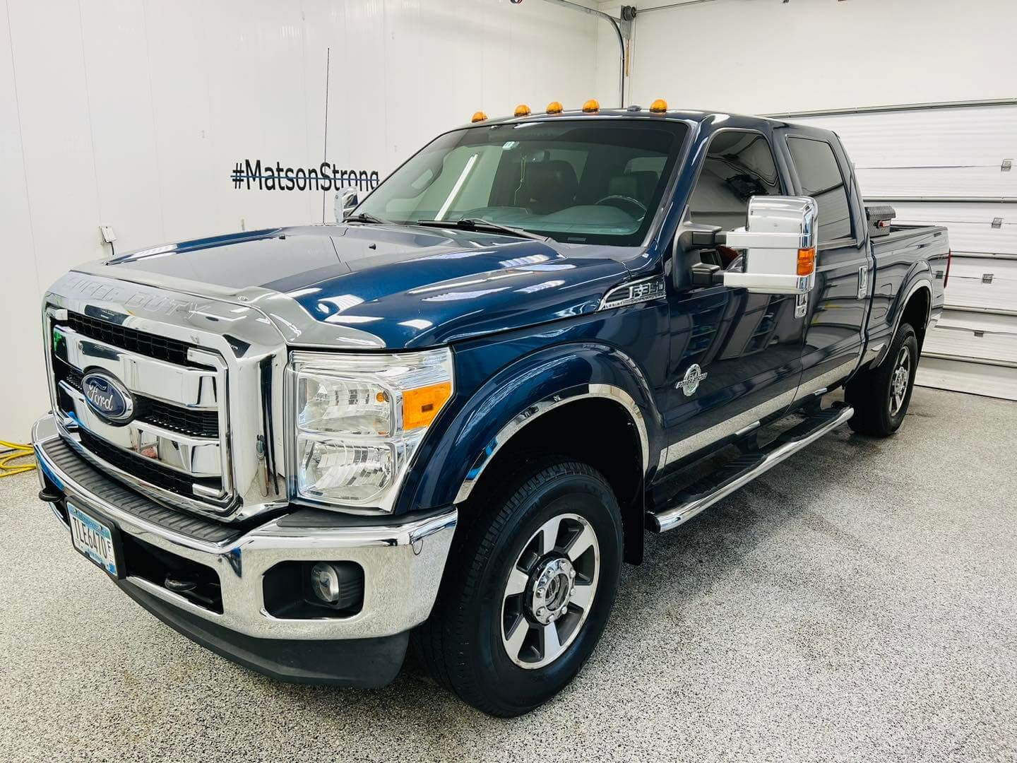 Blue Ford truck in a detailing shop with a shiny exterior