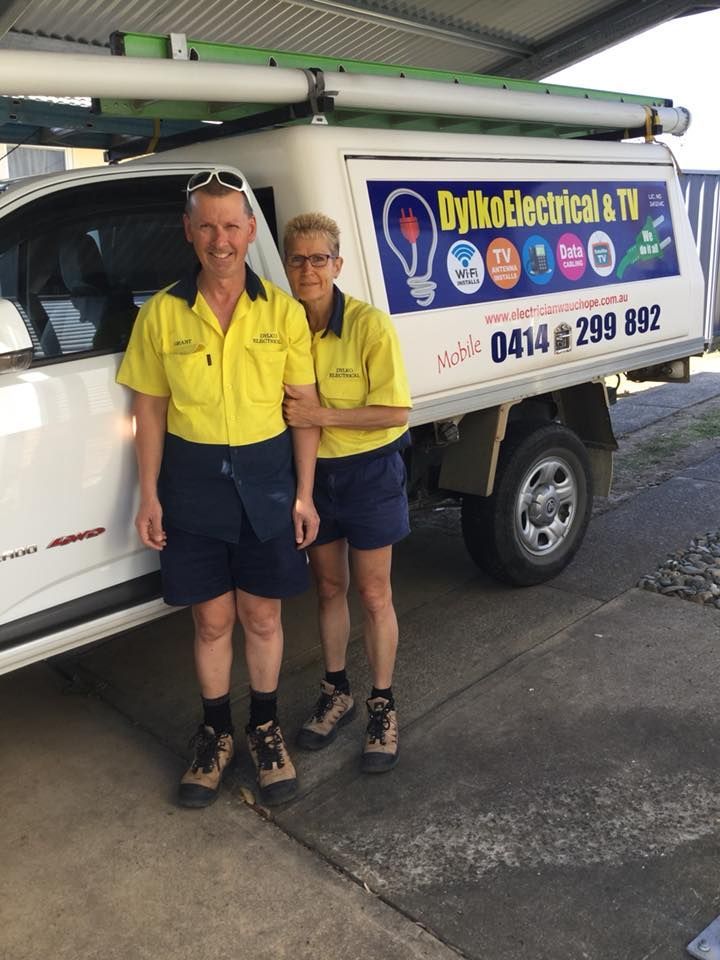 Two People Standing in Front of a Truck That Says Dylko Electrical & TV — Dylko Electrical in Wauchope, NSW