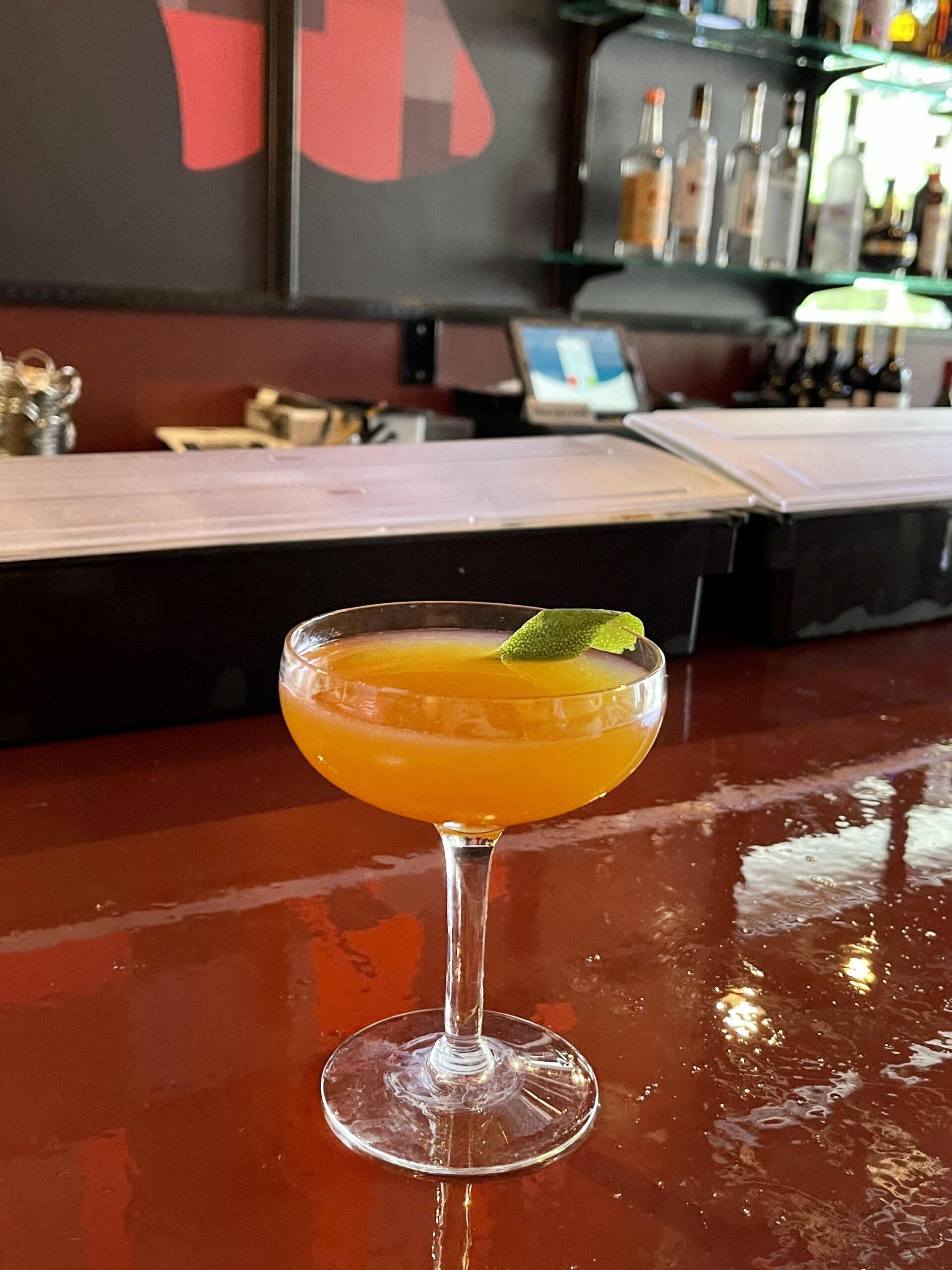 A cocktail in a martini glass on a bar