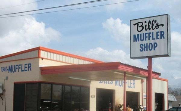 Bill’s Muffler Shop sign above a white and red auto repair building