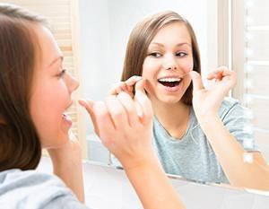 A girl in a mirror flossing - Lincoln, NE - Blome Family Dentistry A girl in a mirror flossing - Lincoln, NE - Blome Family Dentistry