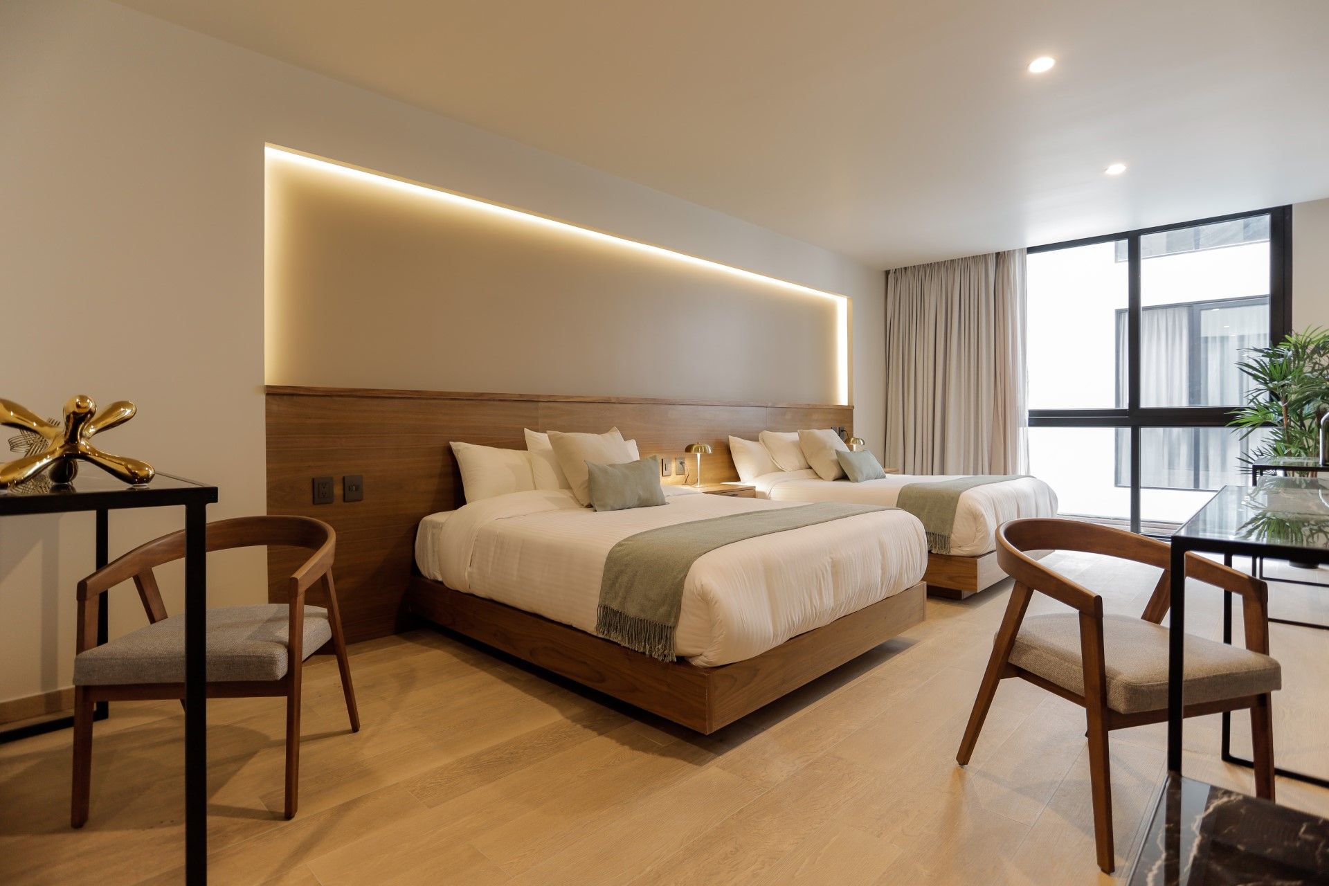 Una habitación de hotel con dos camas, sillas y una mesa.
