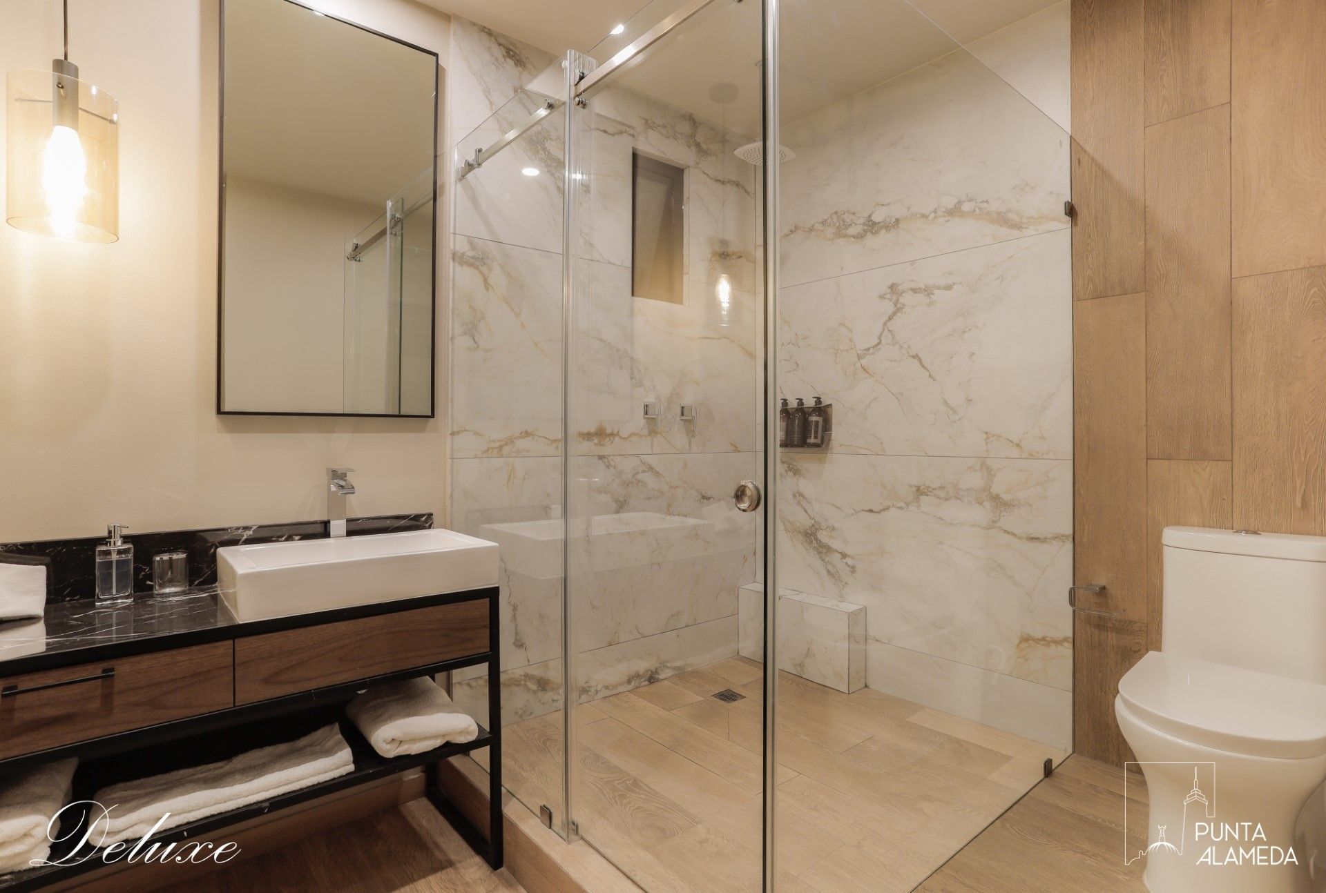 Un baño con inodoro, lavabo, espejo y ducha.
